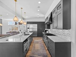 Step into luxury with this stunning kitchen! Featuring sleek, modern cabinetry, a spacious island, and top-of-the-line appliances, this space is perfect for both cooking and entertaining.