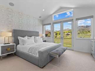 Experience luxury in this stunning bedroom featuring a plush, upholstered bed and a stylish bench.