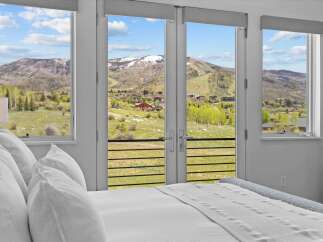 Enjoy breathtaking mountain views from this luxurious bedroom.