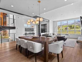 Experience luxury living in this stunning property featuring a spacious dining area with a beautiful wooden table and stylish chairs.