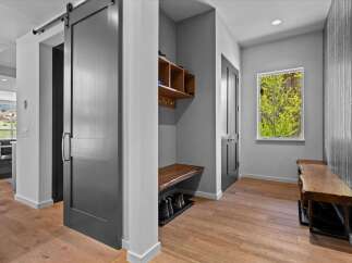 Step into a beautifully designed entryway, featuring a modern barn door and a stylish bench.