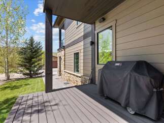 Enjoy outdoor living at its finest with this stunning property featuring a spacious deck and a covered patio area.
