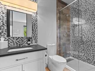 This stunning bathroom features a modern design with a sleek vanity and a spacious shower.