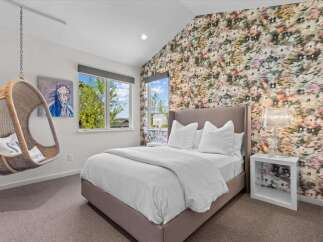 Step into luxury with this stunning bedroom, featuring a unique floral accent wall that adds a touch of elegance.