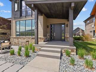 This stunning modern home boasts a striking facade with a combination of stone and wood accents.