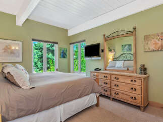 This inviting bedroom boasts a serene atmosphere with its light-colored walls and natural light.