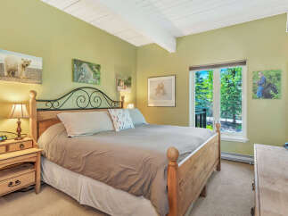 This inviting bedroom features a cozy king-sized bed with a stylish headboard and a warm, neutral color palette.