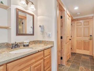 This stunning bathroom features a beautiful vanity with a granite countertop and a stylish sink.