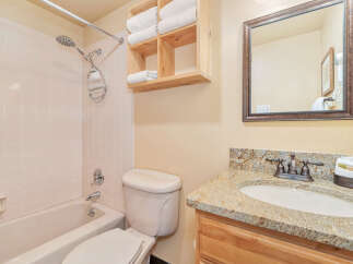 This charming bathroom features a well-lit space with a combination of functionality and style.