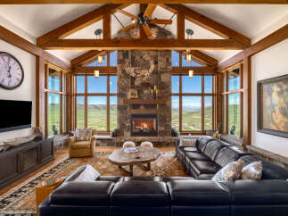 Experience luxury living in this stunning property, featuring a cozy fireplace and expansive windows that frame breathtaking mountain views.