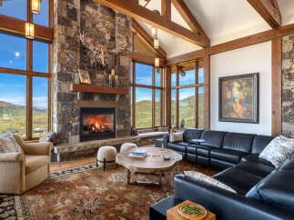 Experience luxury living in this stunning property featuring a cozy fireplace and expansive windows that frame breathtaking mountain views.