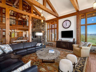 This stunning living room showcases exquisite craftsmanship with its exposed wooden beams and a cozy ambiance.