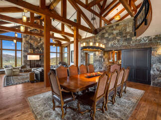 Step into luxury with this stunning dining room, featuring a grand wooden dining table and elegant chairs.
