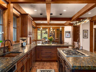 This stunning kitchen boasts custom cabinetry, granite countertops, and a gourmet gas cooktop, perfect for culinary enthusiasts.