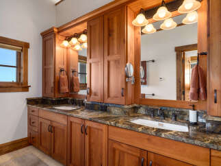 This stunning bathroom boasts custom cabinetry and a luxurious granite countertop, creating a warm and inviting atmosphere.