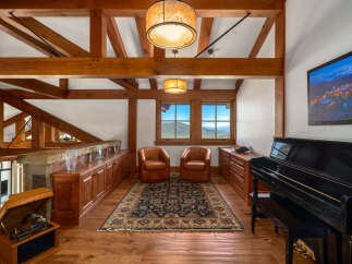 This stunning property boasts a luxurious interior with exposed wooden beams and a grand piano, creating an atmosphere of elegance and comfort.