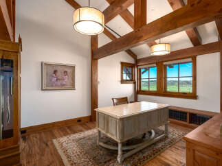 Step into this stunning home office, featuring a beautiful desk and a cozy rug.