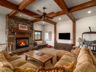 Step into luxury with this stunning living space, featuring a cozy fireplace and exposed wooden beams that exude rustic charm.