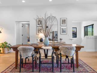 This stunning dining room features a rustic wooden table, perfect for hosting gatherings.