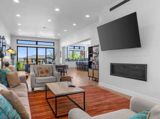 Step into luxury with this stunning living room, featuring a modern fireplace and a sleek, wall-mounted TV.