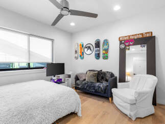 This stylish bedroom features a cozy bed with a plush, white comforter, perfect for relaxation.