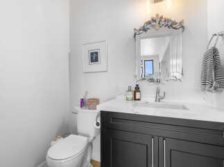 This stunning bathroom boasts a modern design with a sleek vanity and a beautiful mirror.