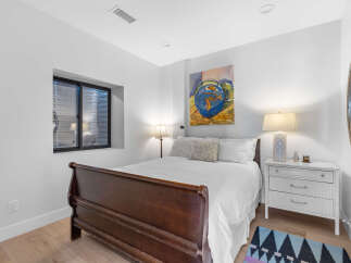 This cozy bedroom features a comfortable bed with a dark wooden frame, creating a warm and inviting atmosphere.