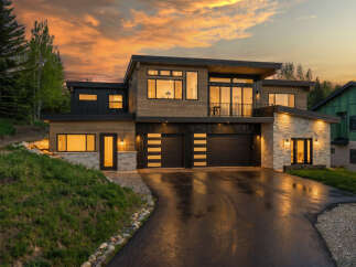 This stunning modern home boasts a sleek design with a mix of wood and stone accents, creating a warm and inviting atmosphere.