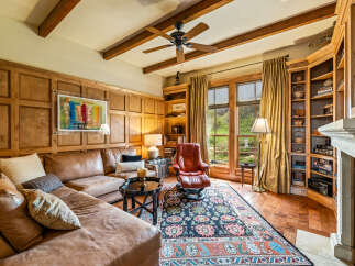 Step into luxury with this stunning living room, featuring exquisite wooden paneling and a cozy leather sectional.