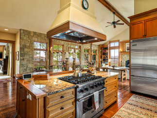 This stunning kitchen boasts a gourmet gas range, granite countertops, and custom cabinetry, perfect for culinary enthusiasts.