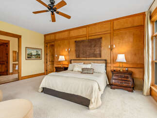Step into luxury with this stunning bedroom featuring exquisite wood paneling and a cozy ambiance.
