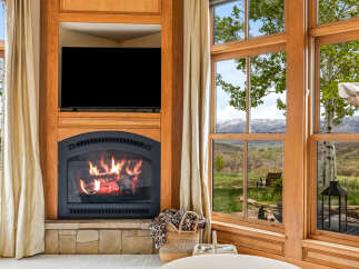 Experience luxury living with this stunning property featuring a cozy fireplace and a large flat-screen TV.