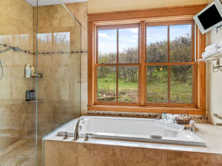 This luxurious bathroom features a stunning combination of natural light and elegant design.