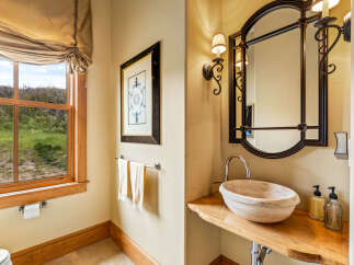 This luxurious bathroom features a unique stone sink and a stylish mirror, creating a spa-like atmosphere.