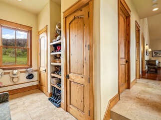 Step into this inviting entryway, showcasing beautiful wooden doors and a convenient shoe storage area.
