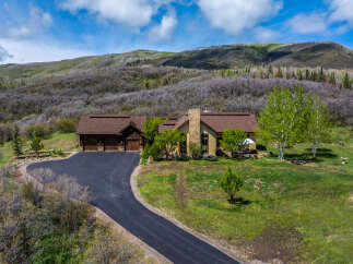 This stunning property boasts a luxurious home with a spacious driveway and a beautiful landscape.