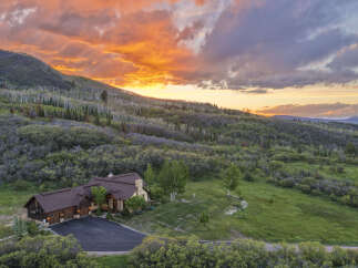 Experience breathtaking mountain living with this stunning property nestled amidst rolling hills and vibrant aspen groves.