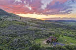 Experience breathtaking sunset views from this stunning mountain home, nestled amidst lush greenery and rolling hills.