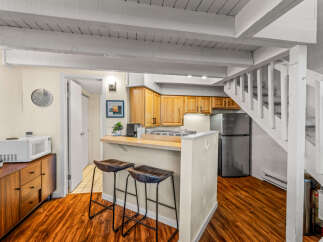This charming property boasts a beautifully designed kitchen with wooden cabinetry and a breakfast bar, perfect for casual dining.
