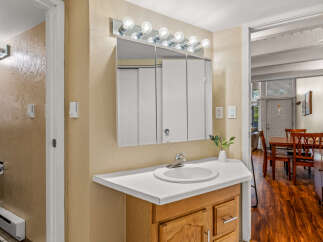 This charming bathroom features a classic vanity with a bright white countertop and a stylish sink.