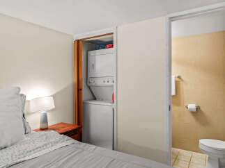 This cozy bedroom features a convenient in-unit laundry setup, perfect for modern living.