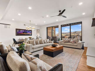 Experience luxury living in this stunning property, featuring a spacious living area with a modern fireplace and large windows that offer breathtaking views.
