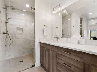 Step into luxury with this stunning bathroom featuring a modern glass-enclosed shower and elegant vanity.