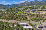 Discover this stunning aerial view of a sprawling university campus nestled amidst majestic mountains and lush green forests.