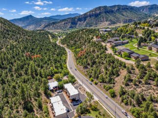 Discover this stunning aerial view showcasing a modern residential complex nestled amidst a picturesque mountain landscape.