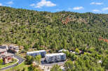 Discover modern living nestled against a backdrop of lush green hills and a clear blue sky.