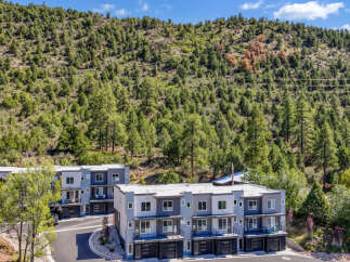 Discover modern living in this stunning townhouse complex nestled against a backdrop of lush green hills.