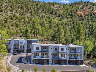 Discover modern living in this stunning townhouse complex nestled against a backdrop of lush green hills.