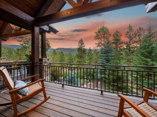 Enjoy breathtaking views from this stunning property! This home features a spacious deck with comfortable rocking chairs, perfect for relaxing and taking in the natural beauty.