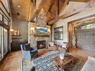 Step into luxury with this stunning living room, featuring a cozy fireplace and a beautiful stone facade.